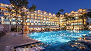 A hotel with a large swimming pool, multiple balconies, and outdoor seating areas. - Berry Blue Hotels - All Inclusive (Manavgat)