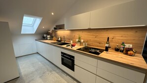 Eine moderne Küche mit Oberlicht, eingebauten Geräten und einer Holz Arbeitsplatte.