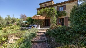 A rustic stone house with a garden patio, a wooden staircase, and a table with chairs. - Stunning private villa for 8 people with WIFI, private pool, A/C, TV and panoramic view (Cortona)