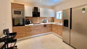Una cucina moderna con elettrodomestici integrati, mobili in legno e un frigorifero in acciaio inossidabile.