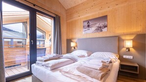 Un dormitorio con paneles de madera, una cama, dos lámparas de noche y un cuadro en la pared.
