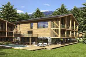 A modern wooden cabin with a pool, outdoor seating, and a stone fireplace.