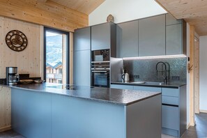 Enjoy cooking in this well-designed kitchen with a large island and appliances, offering a view of the surrounding landscape.