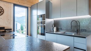 Una cocina moderna con encimera de granito, electrodomésticos de acero inoxidable y vistas al exterior.