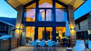 A modern two-story building with a wooden exterior and large windows. - Panorama holiday home with sauna (No Deposit) (Sankt Georgen am Kreischberg)