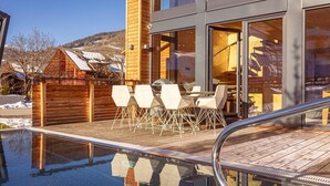 A modern building with a wooden deck and a swimming pool. - Panorama holiday home with sauna (No Deposit) (Sankt Georgen am Kreischberg)
