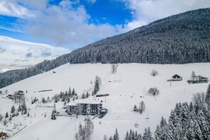 Montanha coberta de neve com estação de esqui, incluindo edifícios e teleféricos.