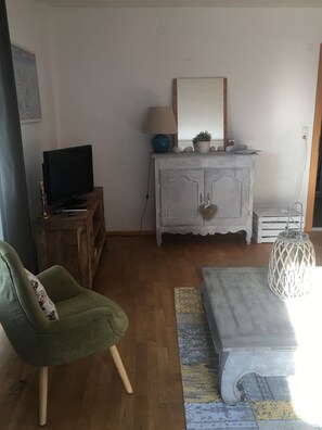 Relax in this inviting living room with a comfortable armchair, a stylish cabinet, and a convenient table with a lamp.
