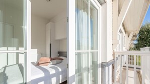 Une chambre à coucher moderne avec un lit, une table de chevet et une fenêtre.