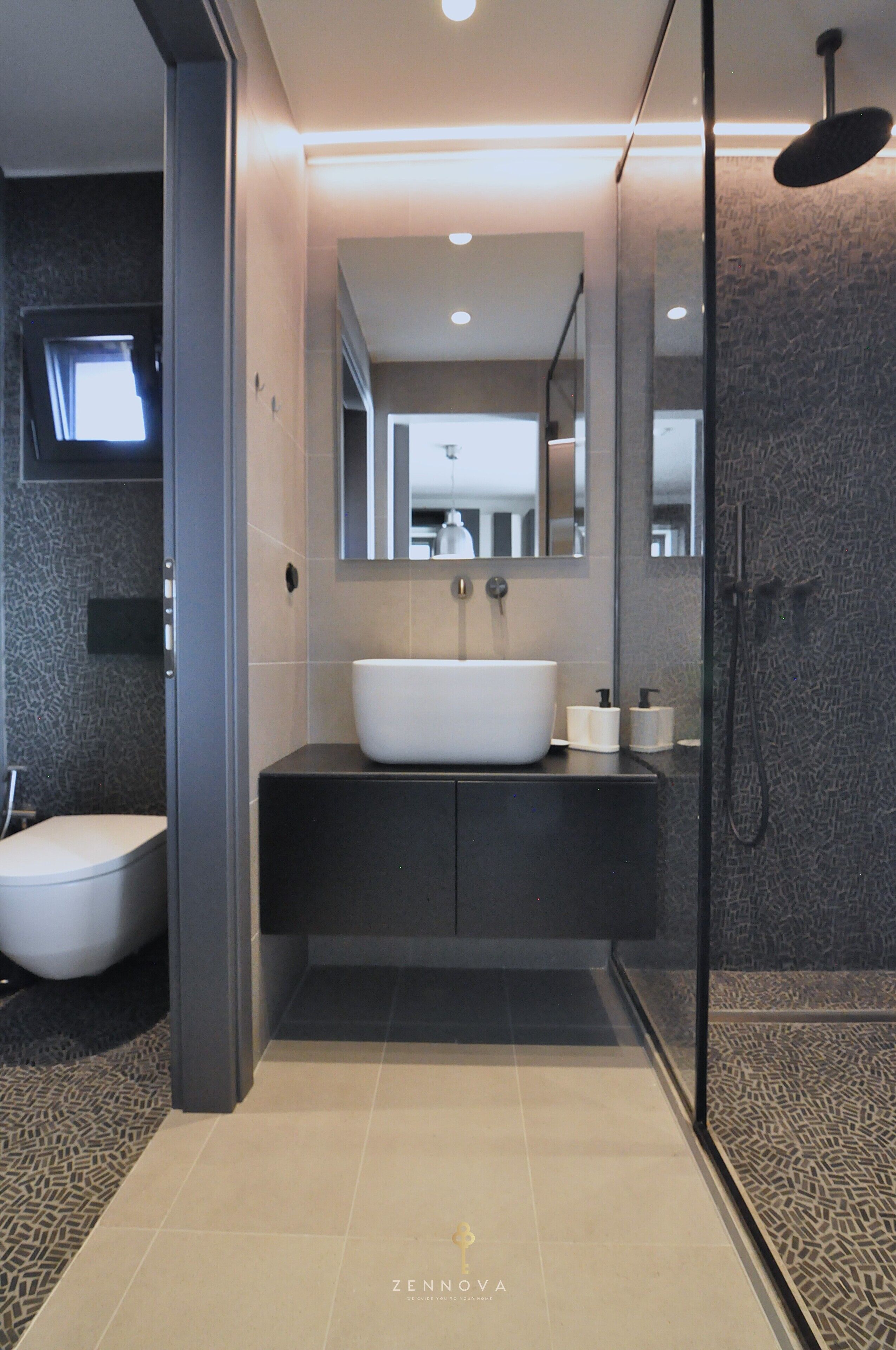 A modern bathroom with a large white sink, dark cabinetry, a glass shower enclosure, and a mirror above the sink.
