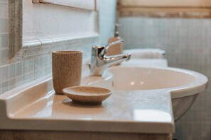 A bathroom with a white sink, a mirror, and a towel rack. - terrance apartment - air conditioning | 5 minute sea | - VinTage Malvasia (Diso)