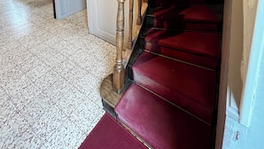A staircase with wooden balusters and red carpeted steps leading to a landing. - 15-person gite with 6 bedrooms and bar area ideal for family reunions! (Varzy)