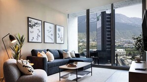 Un salon moderne avec un canapé, une table basse et une grande fenêtre donnant sur la ville.