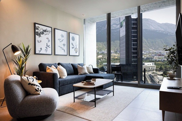 Spacious living room with floor-to-ceiling windows, offering stunning mountain views