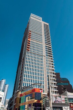 A tall, modern skyscraper with a grid-like facade and numerous windows.