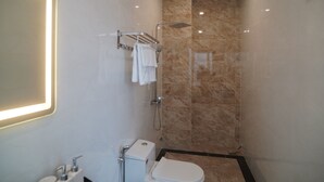 Une salle de bain moderne équipée de toilettes, d’un lavabo et d’une douche.