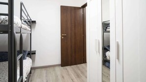 Una habitación con literas, un armario y una puerta.