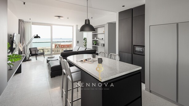 A modern kitchen with a central island, a dining area with a view, and a balcony with a cityscape view. - Nero Luxury Suites by Zennova (Thessaloniki)