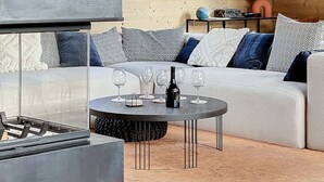 Ein modernes Wohnzimmer mit einer Couch, einem Couchtisch und einem Gemälde an der Wand.