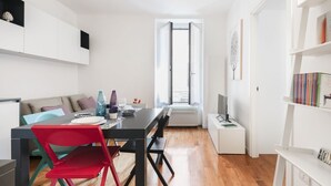 A modern, well-lit living space with a dining area, a sofa, and a bookshelf. - Easylife - A touch of design in Porta Venezia (Milano)