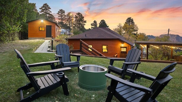 A wooden cabin with a porch, a fire pit, and Adirondack chairs. - JoLee Pines, Close to attractions (Lead)