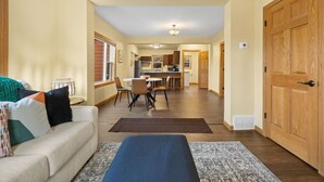 A modern living room with a sofa, a coffee table, and a dining area with chairs and a table. - JoLee Pines, Close to attractions (Lead)