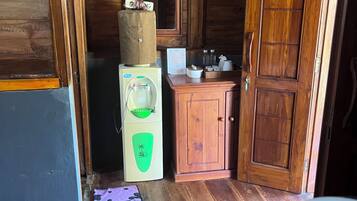 A compact wooden cabin with a kitchenette, a wooden door, and a small window.