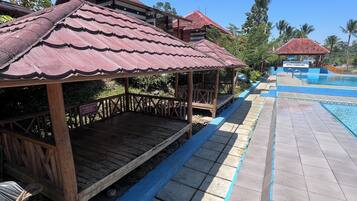 A resort with wooden structures and a swimming pool.