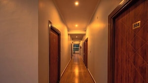 A hotel hallway with wooden doors, a number sign '304' on one door, and a wooden floor. - Hotel Rishikesh Grand by Kool-stays (Rishikesh)