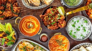 A variety of Indian dishes including curry, rice, and bread, served on metal plates and bowls. - Hotel Rishikesh Grand by Kool-stays (Rishikesh)