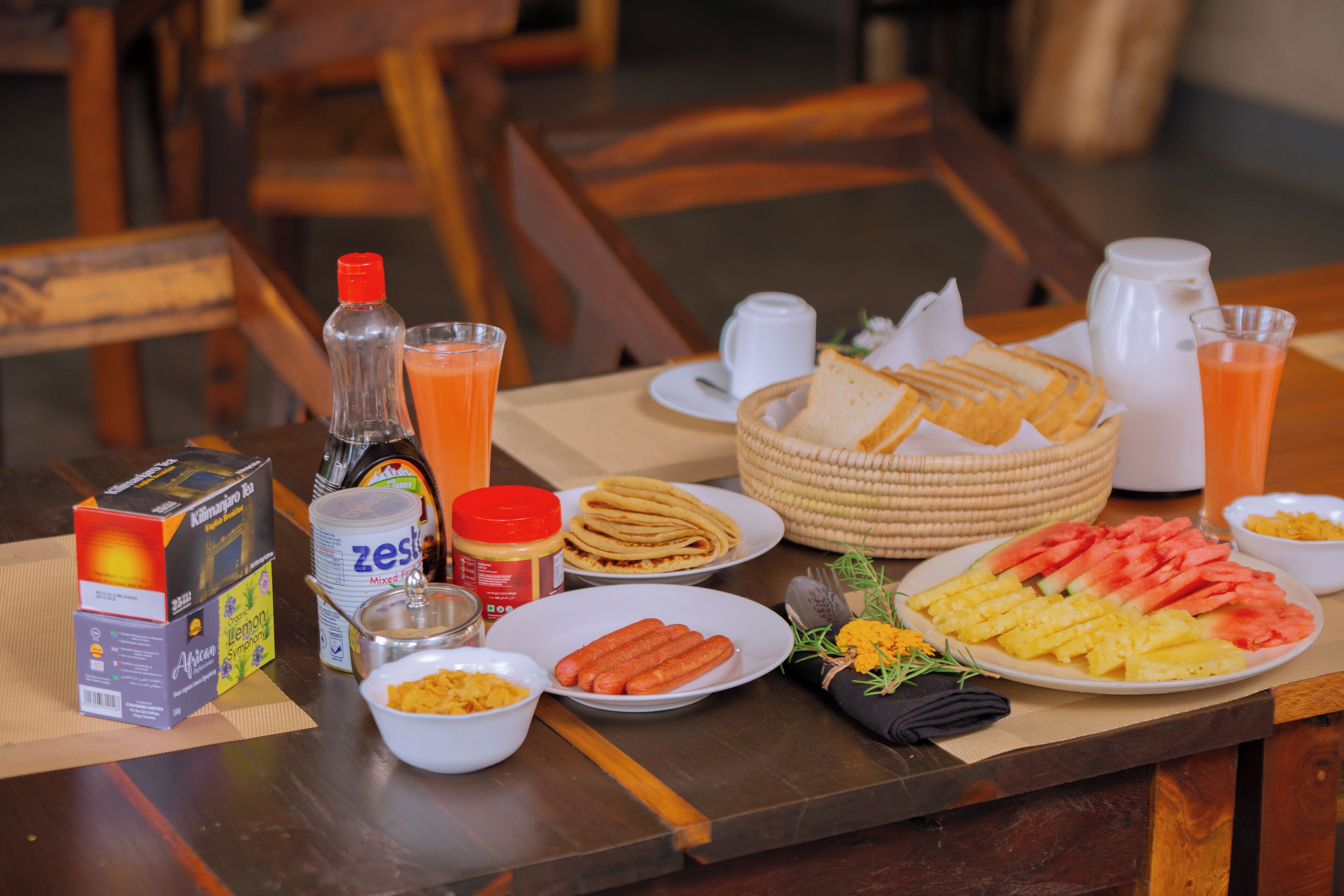 Una tavola imbandita per la colazione con salumi, pane e un piatto di frutta.