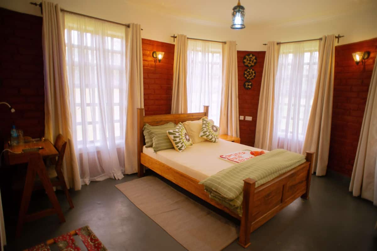 A bedroom with a wooden bed, a desk, and a chair.
