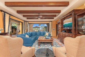 A living room with a blue sofa, wooden coffee table, and wicker chairs.