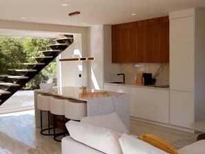 A modern kitchen with a marble countertop, wooden cabinets, and a built-in stove.