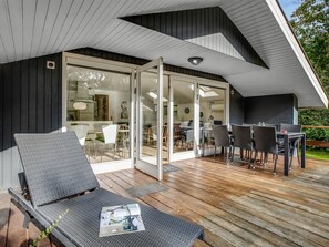 A modern outdoor deck with a glass door leading to a dining area, featuring a wooden deck and outdoor furniture. - "Dimo" - 30km from the sea by Interhome (Toftlund)