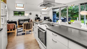 A modern kitchen with a central island, a dining area with a view, and a cozy seating space. - "Dimo" - 30km from the sea by Interhome (Toftlund)