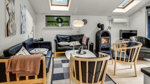 A modern living room with a sofa, armchair, and a small table. There are skylights, a fireplace, and a TV. - "Dimo" - 30km from the sea by Interhome (Toftlund)