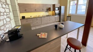 Uma cozinha moderna com armários de madeira, uma ilha central e um forno embutido.