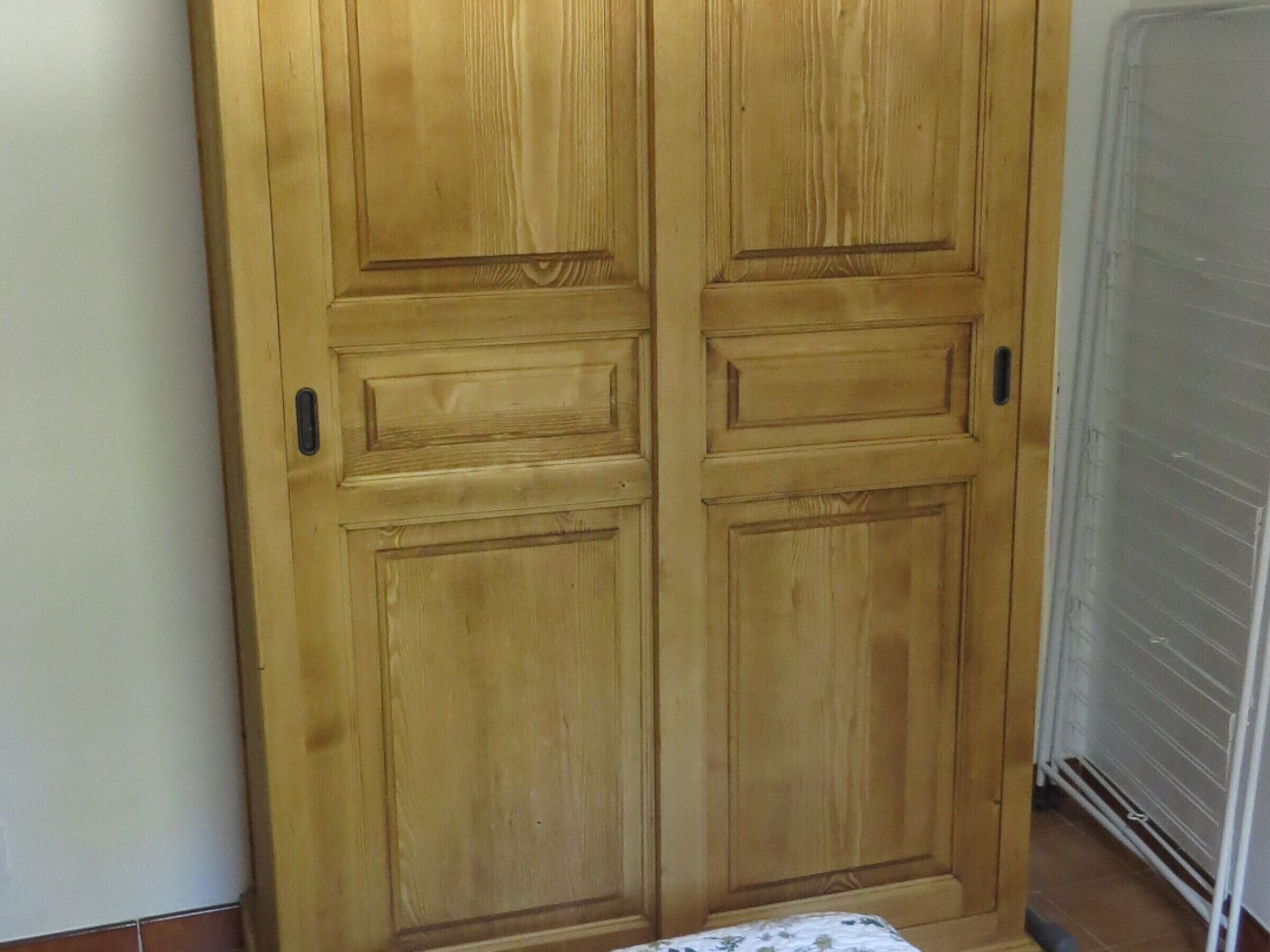 Une porte à deux battants en bois, au design simple, dotée d’une petite poignée et d’une serrure.