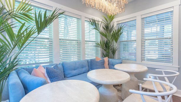 A modern living room with a blue sectional sofa, round tables, and a large plant. - Designer Downtown Home, Assn Pool, Walk To Beach (New Buffalo)