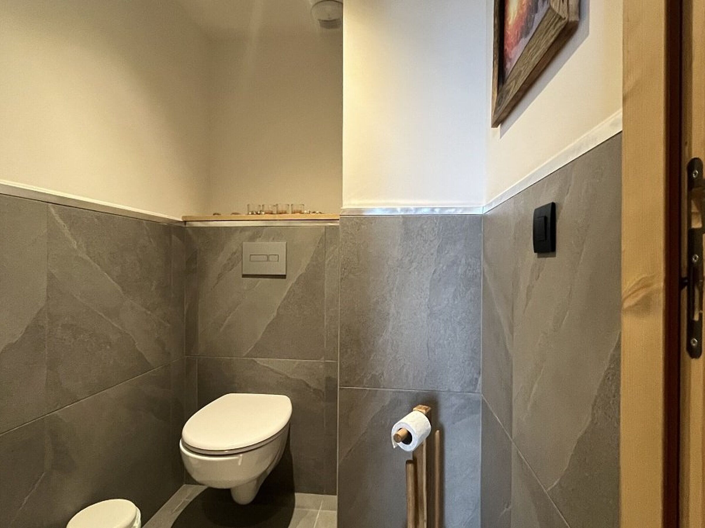A bathroom with a toilet, a shower, and a towel rack.