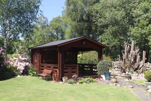 Idyllic countryside haven with lush landscape, manicured garden, pond and stream