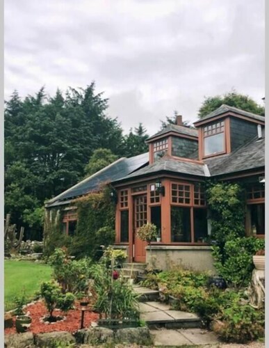 Idyllic countryside haven with lush landscape, manicured garden, pond and stream