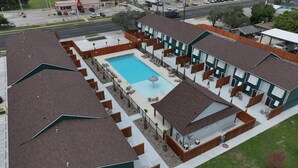 Un hôtel doté d’une piscine, d’un espace extérieur aménagé et d’un bâtiment surmonté d’un toit végétalisé.