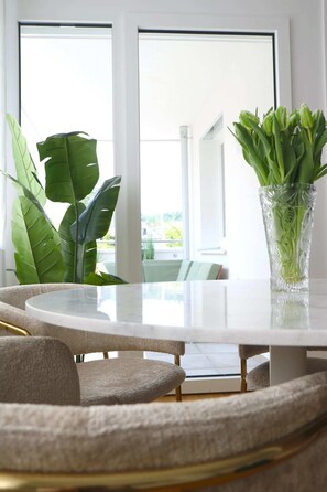 Un comedor moderno con una mesa redonda, sillas cómodas y un jarrón con plantas verdes.