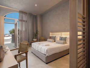 Een moderne slaapkamer met een groot bed, een houten hoofdbord, een tafeltje met een plant en uitzicht op buiten.