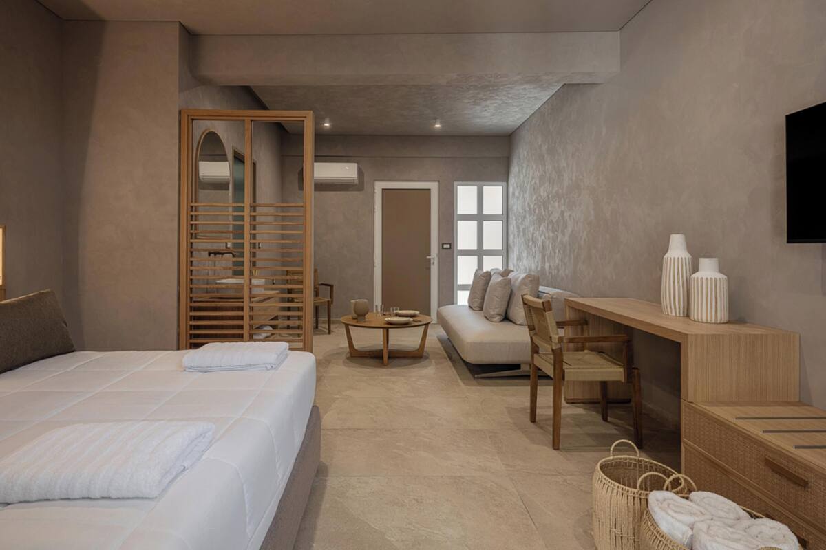 Une chambre d’hôtel moderne équipée d’un lit, d’un canapé, d’un bureau et d’une télévision.