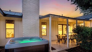 Una casa con jacuzzi, terraza techada y comedor.