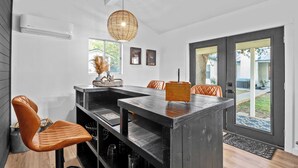 Una cocina moderna con una isla central, armarios negros y un lámpara colgante.