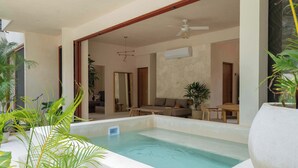 A modern indoor pool area with a seating area and a ceiling fan. - Catch Soulful Vibes at AHAL II! Enjoy a private plunge pool and a communal pool! (Tulum)